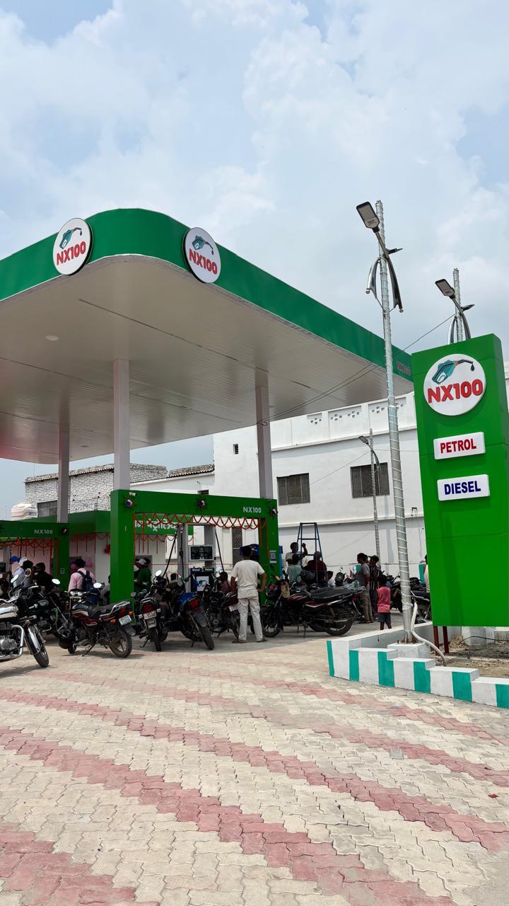 NX100 station canopy with petrol and diesel signage and customers at the pumps